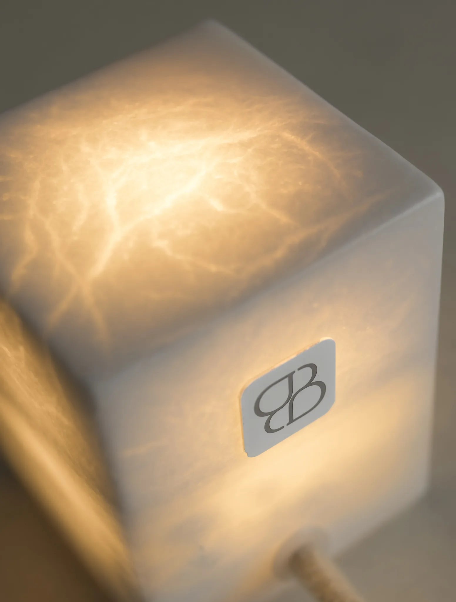 Detalle de las vetas iluminadas y el logotipo de una lámpara de alabastro BARLET.