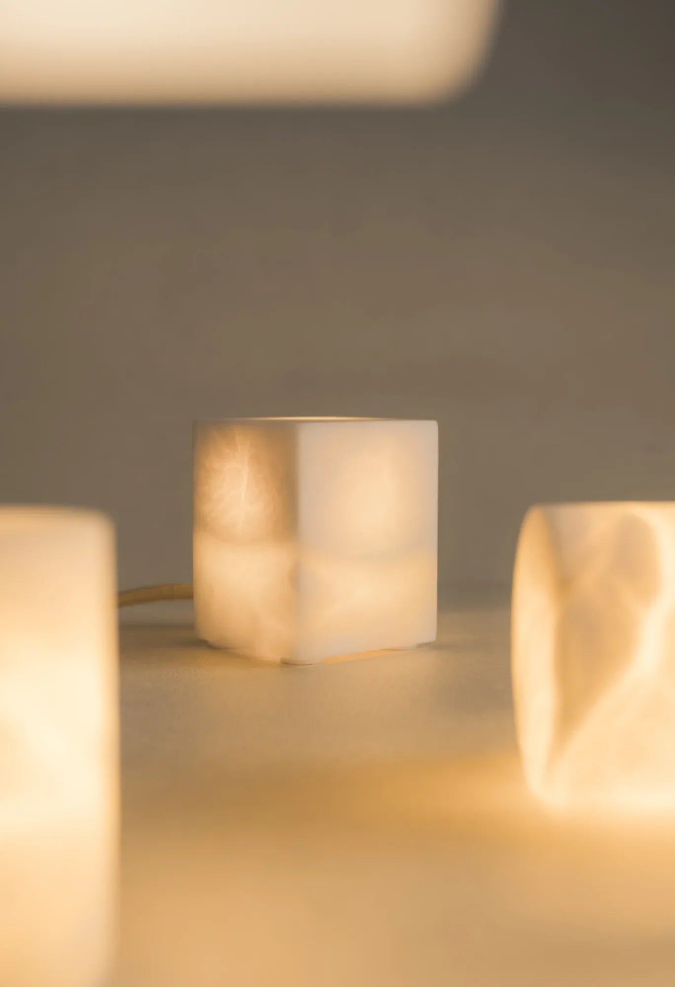 Varias lámparas de alabastro BARLET encendidas, con luz cálida y distintos planos de enfoque.