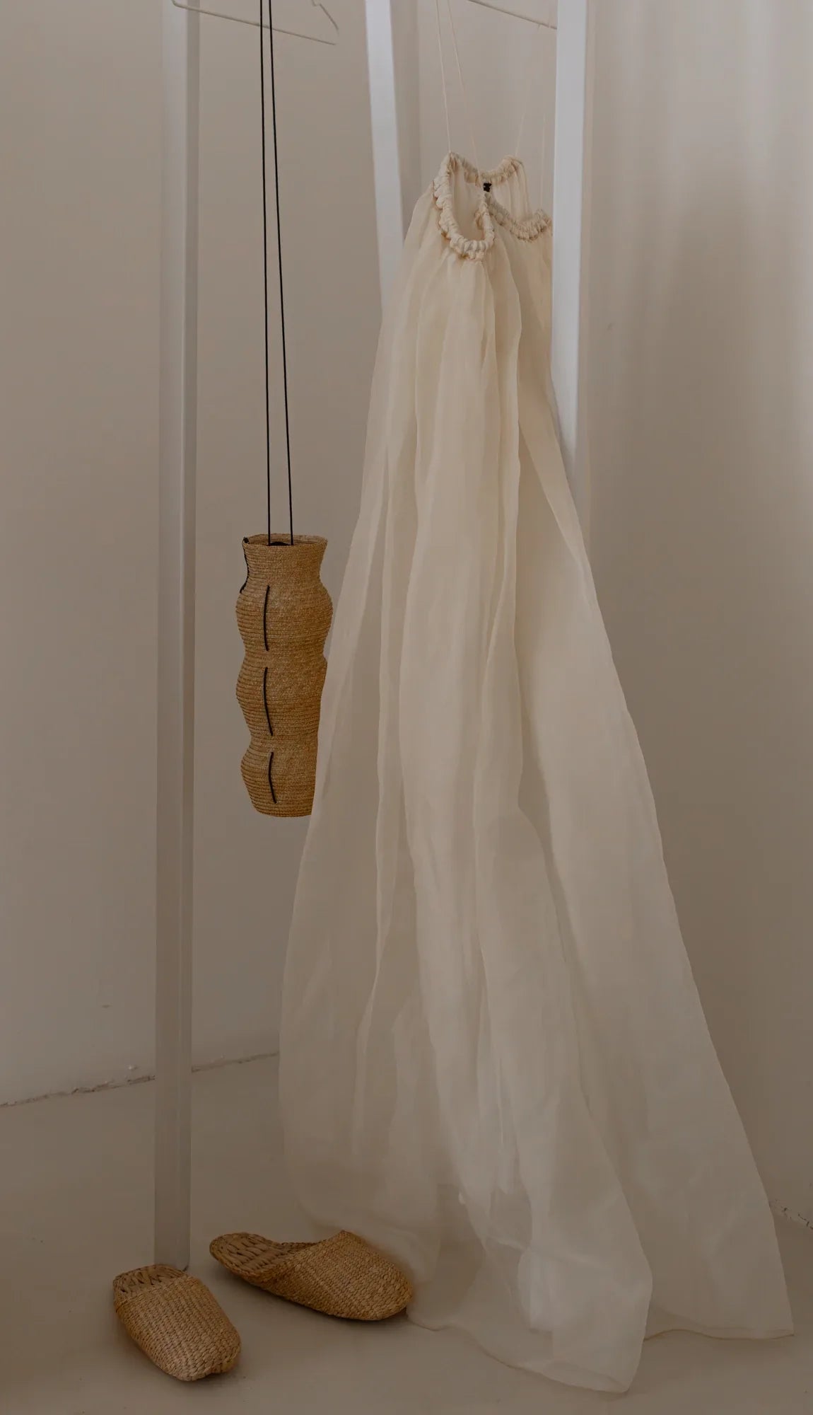 Detalle de una cortina blanca y una pieza de madera en el interior de OASIS.